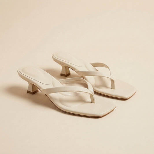 Sandalias de dedo con tacón bajo sobre fondo neutro